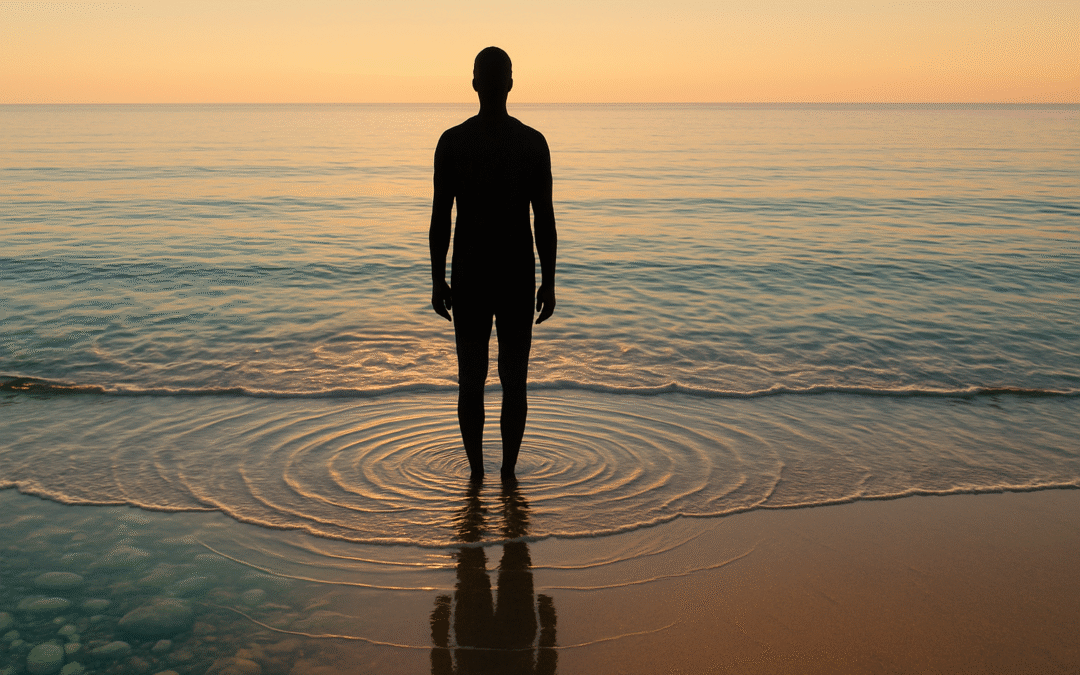 Person standing at the water's edge where ocean meets shore, their reflection visible in wet sand, demonstrating the interconnection between individual and environment